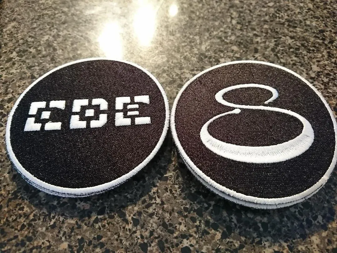 Two circular embroidered coffee patches with white borders